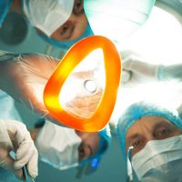 Now try to sleep. Low angle of professional surgeons giving to patient a general anesthetic before an operation. They are holding the equipment and surgical instruments